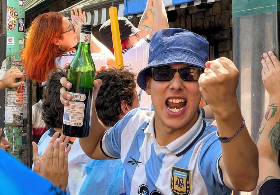 Un local sosteniendo una botella de Fernet durante la celebraciÃ³n del triunfo de Argentina en el Mundial.